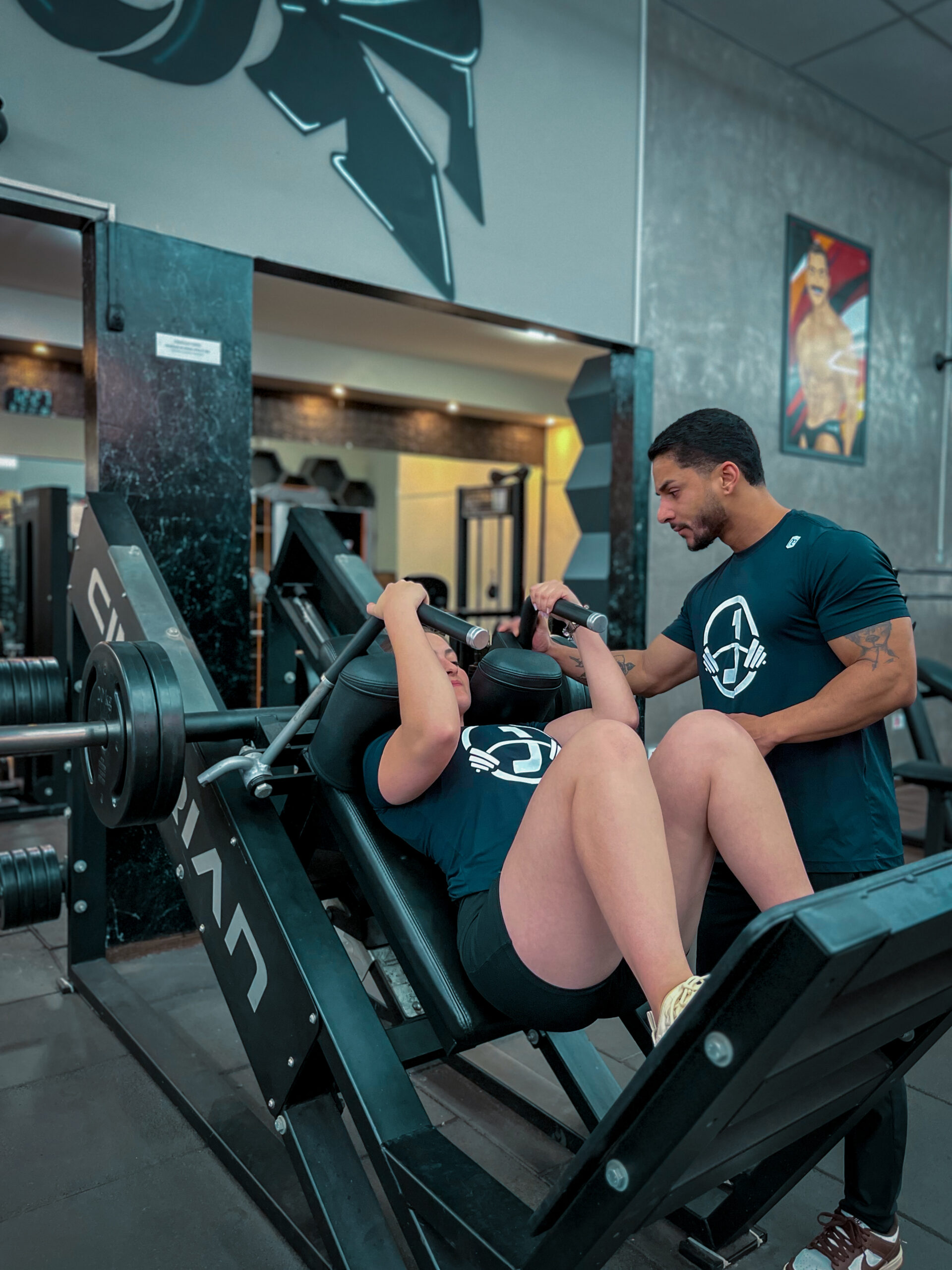 Jonathan Souza e sua aluna no leg press